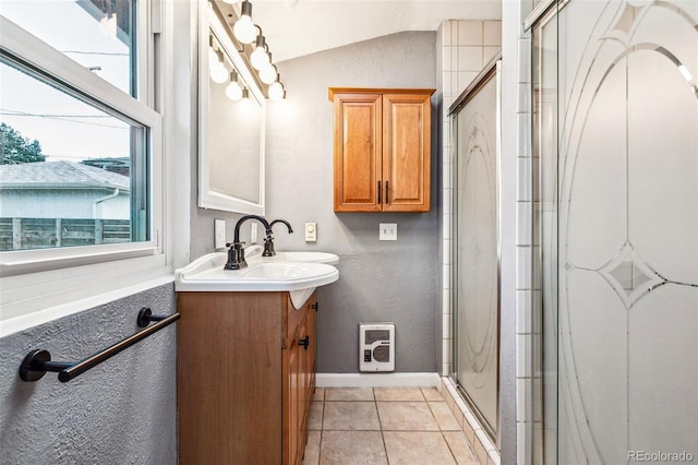 full bath featuring tile patterned flooring, a shower stall, baseboards, vaulted ceiling, and vanity