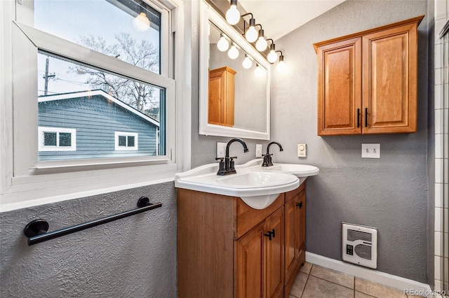 bathroom with visible vents, baseboards, a textured wall, tile patterned floors, and vanity