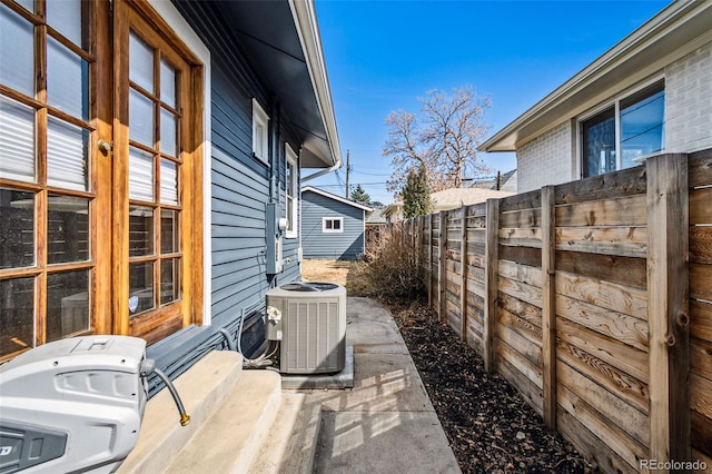 exterior space with central AC unit and fence