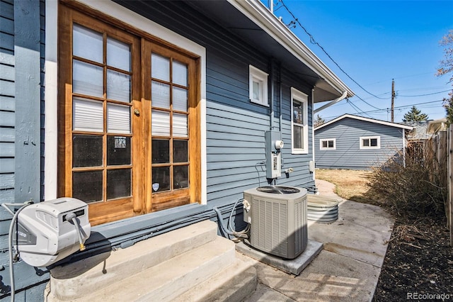 view of patio / terrace with central air condition unit and fence