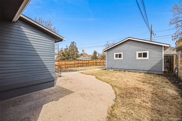 view of yard featuring a patio, an outbuilding, and a fenced backyard