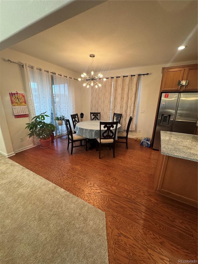 dining area with dark hardwood / wood-style flooring and a notable chandelier