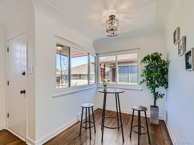 dining area featuring dark hardwood / wood-style floors and an inviting chandelier