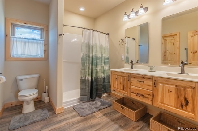 bathroom with a shower with shower curtain, vanity, hardwood / wood-style flooring, and toilet