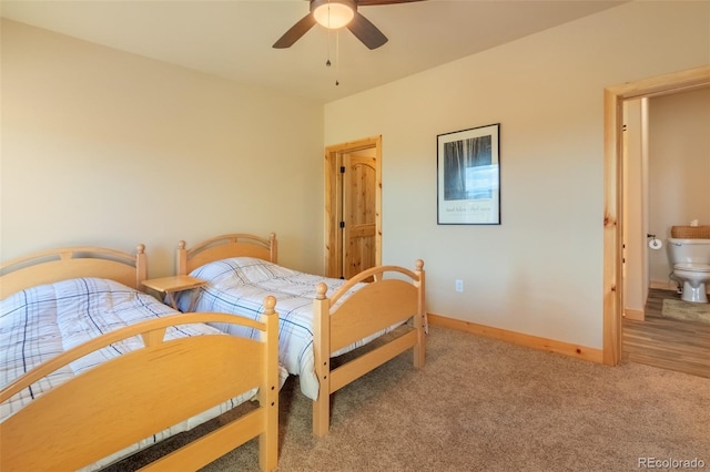 bedroom with ceiling fan, light colored carpet, and connected bathroom