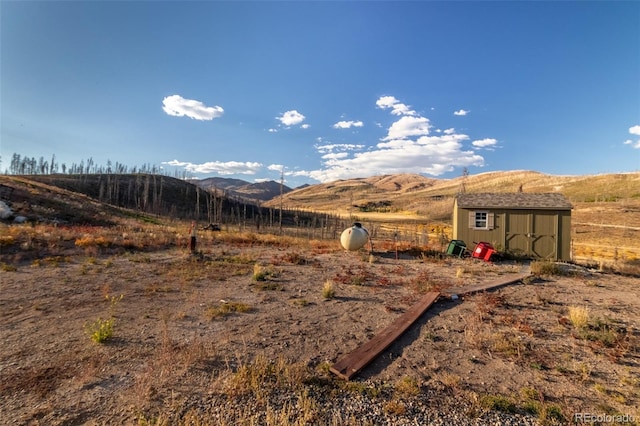 view of yard with a mountain view, a rural view, and a shed