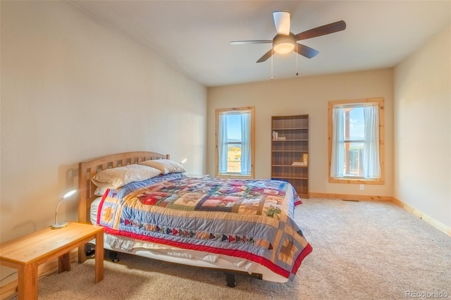 carpeted bedroom featuring baseboards and a ceiling fan