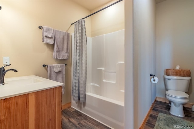 full bathroom with toilet, wood finished floors, a sink, shower / tub combo with curtain, and baseboards