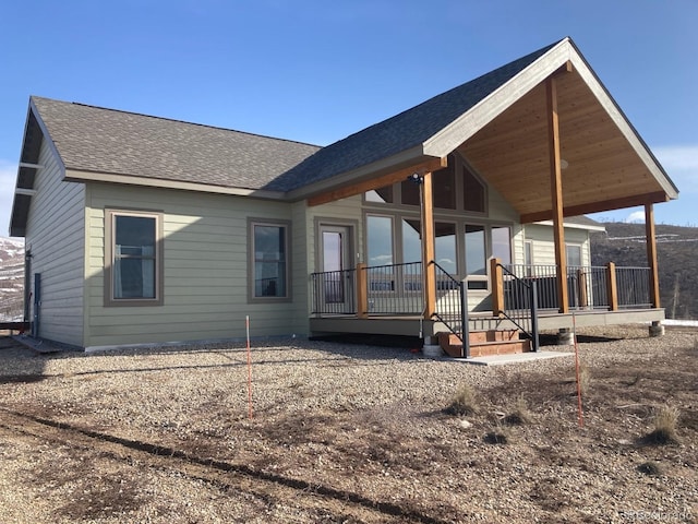 exterior space featuring a porch and roof with shingles