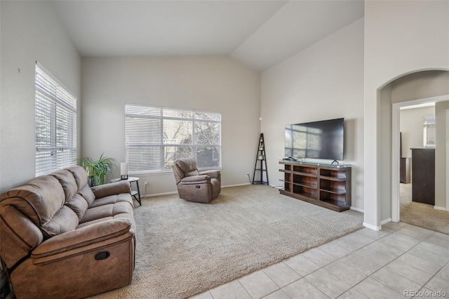 living area featuring high vaulted ceiling, carpet, tile patterned flooring, and baseboards