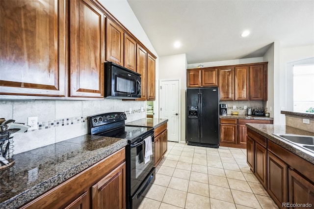 kitchen with lofted ceiling, light tile patterned floors, tile counters, decorative backsplash, and black appliances