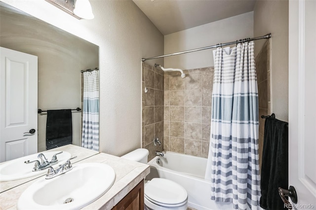 full bathroom featuring a textured wall, shower / tub combo, vanity, and toilet