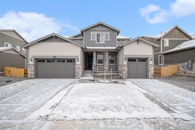 craftsman house with stone siding, a porch, a garage, and fence