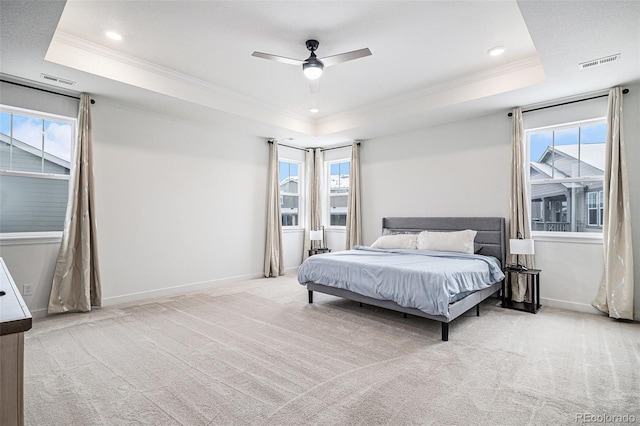 carpeted bedroom featuring ceiling fan, ornamental molding, and a raised ceiling