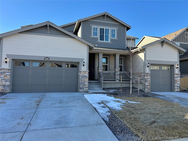 craftsman inspired home featuring concrete driveway, covered porch, a garage, and stone siding