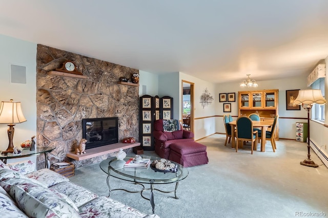 living room with carpet floors, baseboards, a notable chandelier, and a stone fireplace