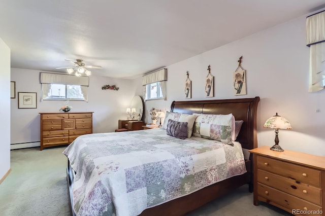 carpeted bedroom featuring a ceiling fan and a baseboard heating unit