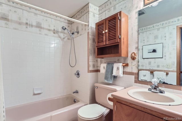 bathroom with vanity, washtub / shower combination, toilet, and wallpapered walls