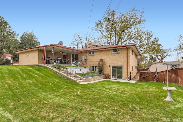 back of property featuring brick siding, a fenced backyard, ceiling fan, and a patio area