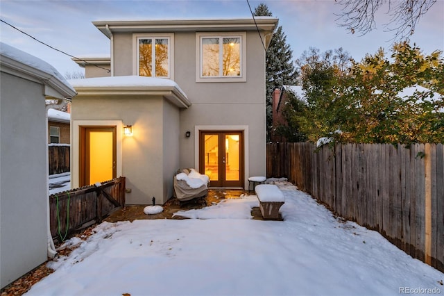 snow covered house with french doors