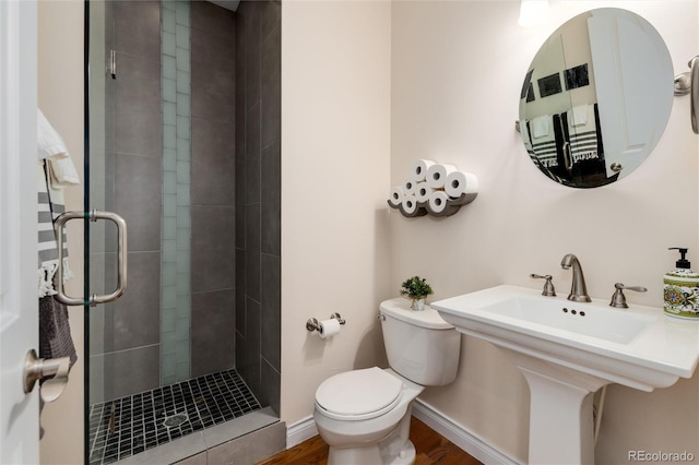 bathroom featuring hardwood / wood-style flooring, toilet, a shower with shower door, and sink