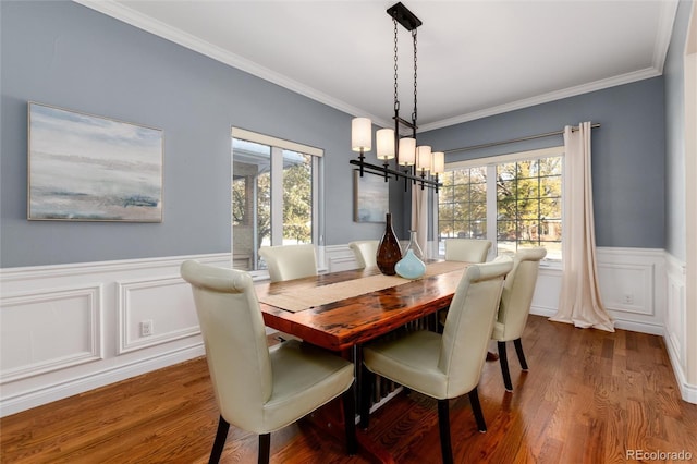 dining space with hardwood / wood-style flooring, plenty of natural light, and ornamental molding