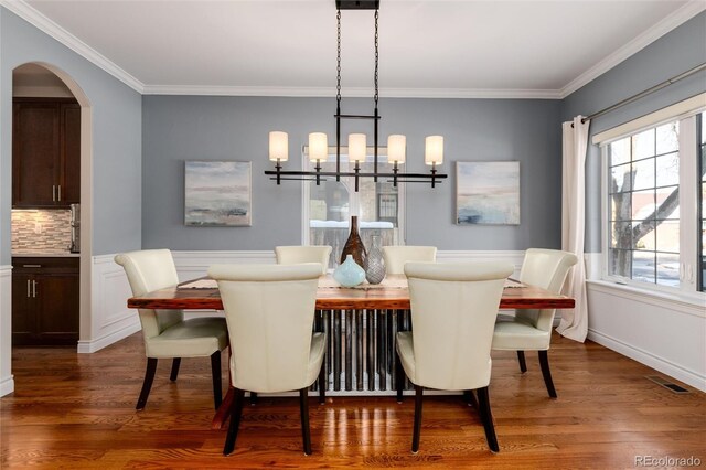 dining room with a chandelier, dark hardwood / wood-style floors, and ornamental molding