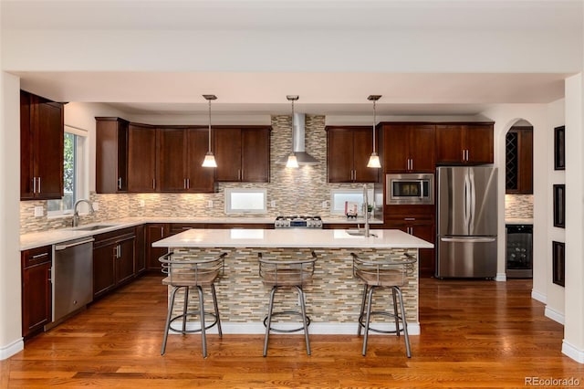 kitchen with a kitchen breakfast bar, a center island, decorative light fixtures, and appliances with stainless steel finishes