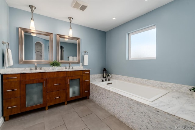 bathroom featuring tile patterned floors, vanity, and a relaxing tiled tub