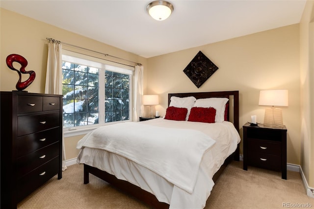 bedroom with baseboards and light carpet