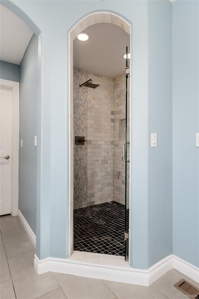 full bathroom with a shower stall, baseboards, and tile patterned flooring