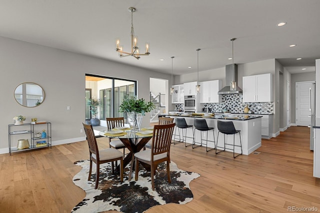 dining space with an inviting chandelier and light hardwood / wood-style floors