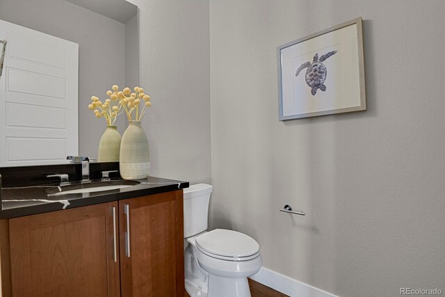 bathroom with vanity, toilet, and hardwood / wood-style floors