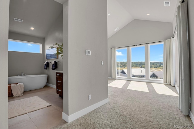 corridor featuring high vaulted ceiling and light colored carpet