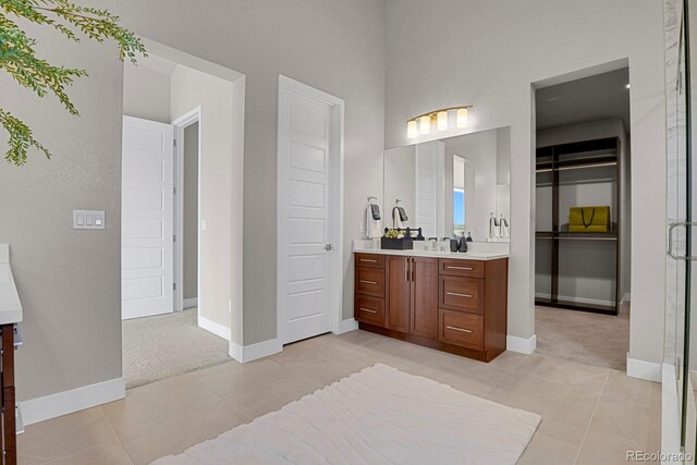 bathroom featuring vanity, a shower with shower door, and tile patterned flooring