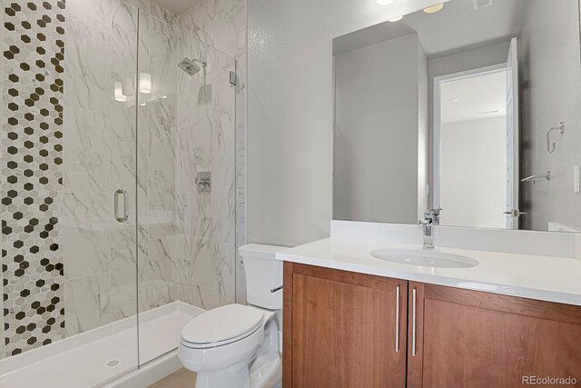 bathroom featuring a shower with shower door, toilet, and vanity