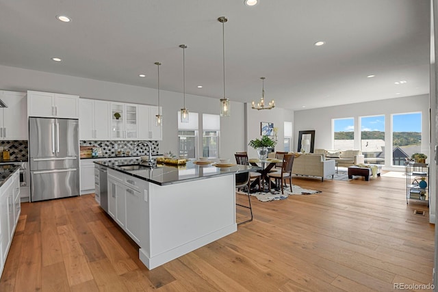 kitchen with stainless steel appliances, light wood-type flooring, and white cabinetry