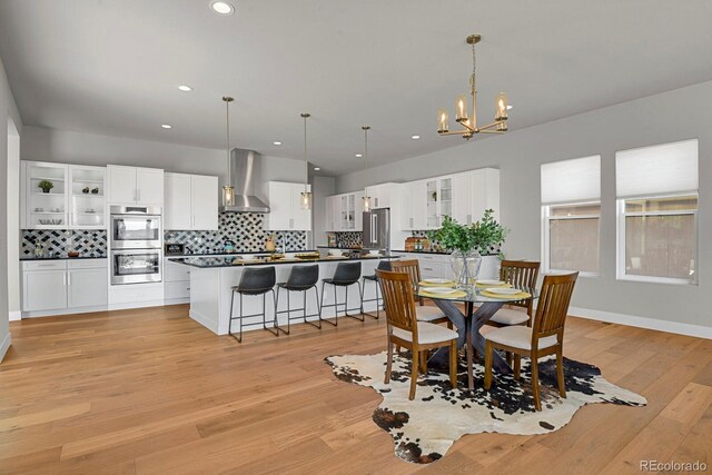 dining room with an inviting chandelier and light hardwood / wood-style floors