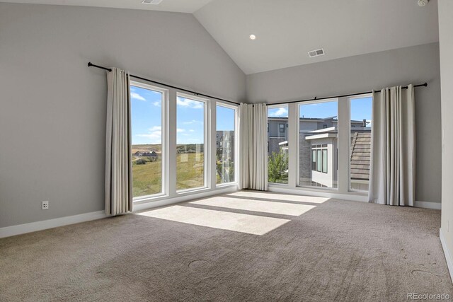 carpeted empty room featuring high vaulted ceiling