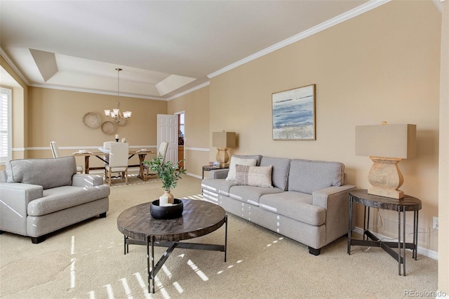 carpeted living room featuring a raised ceiling, ornamental molding, and a chandelier