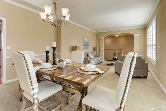 carpeted dining area featuring ornamental molding, a chandelier, and decorative columns