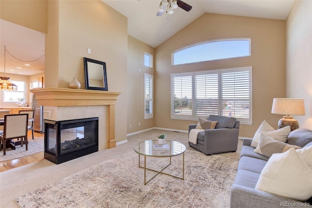 carpeted living room with a fireplace, high vaulted ceiling, and ceiling fan