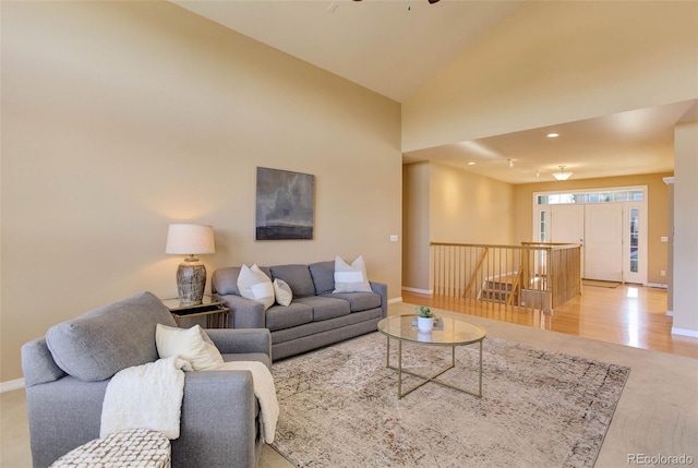 living room with high vaulted ceiling, ceiling fan, and light wood-type flooring