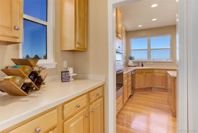 kitchen with light wood-type flooring, sink, and light brown cabinets