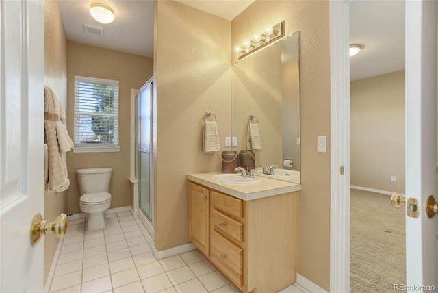 bathroom featuring an enclosed shower, vanity, tile patterned floors, and toilet