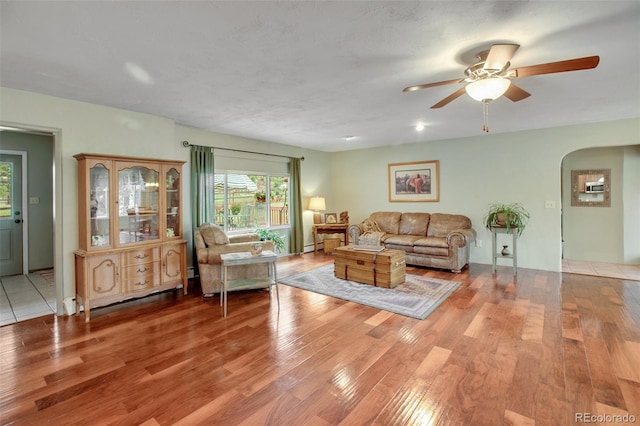 living room with ceiling fan, a textured ceiling, and hardwood / wood-style floors