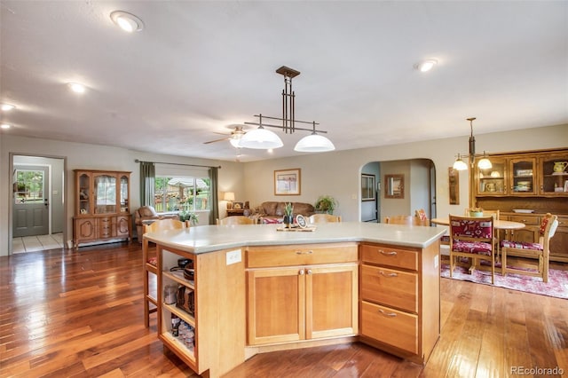kitchen featuring ceiling fan, a center island, and dark hardwood / wood-style floors
