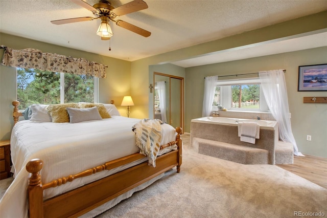 bedroom with a closet, ceiling fan, light wood-type flooring, and a textured ceiling