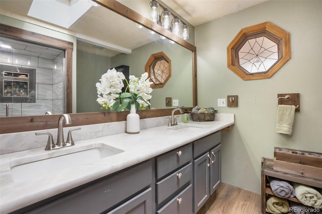 bathroom with wood-type flooring, a textured ceiling, and vanity