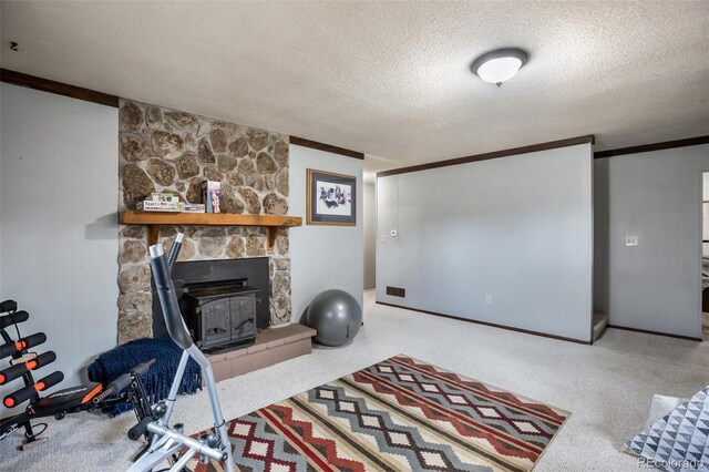 interior space featuring a textured ceiling, a fireplace, ornamental molding, and a wood stove